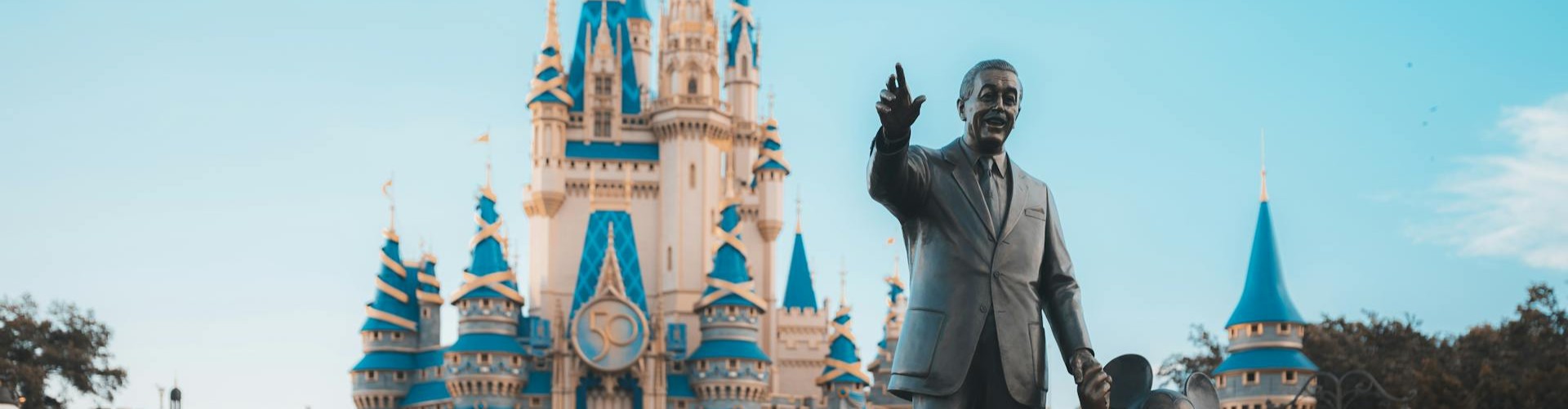 Fairytale castle with blue spires and a bronze statue at an Orlando theme park